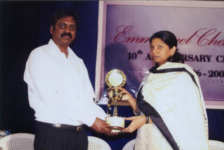 Ebenezer Joseph, India's first FIDE trainer, receiving an award from Smt. Kanimozhi, Member of Parliament